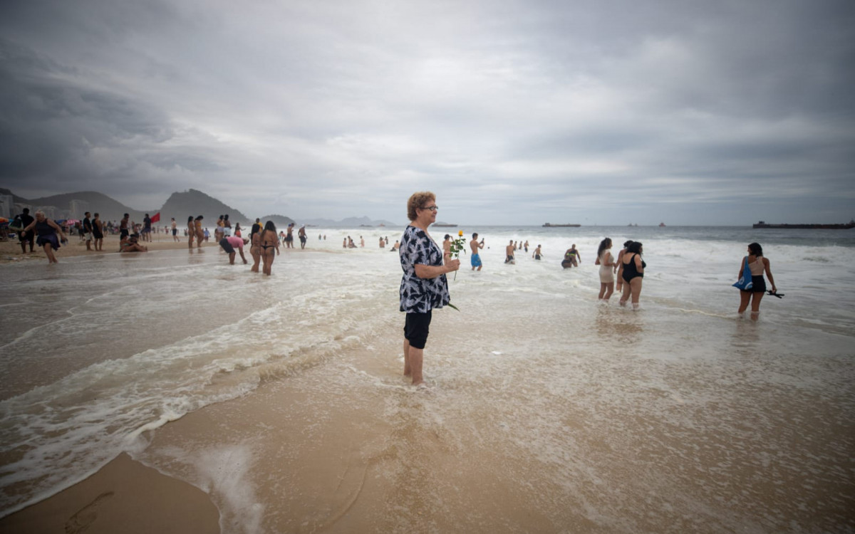 Mara Lourete, 71 anos, joga flor ao mar - Foto: Renan Areias / Agência O Dia