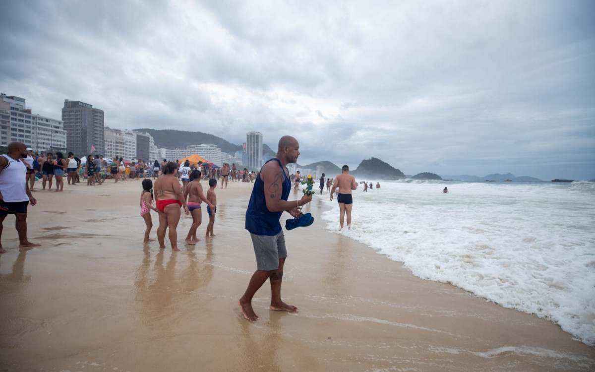Adepto joga flor no mar de Copacabana - Foto: Renan Areias / Agência O Dia