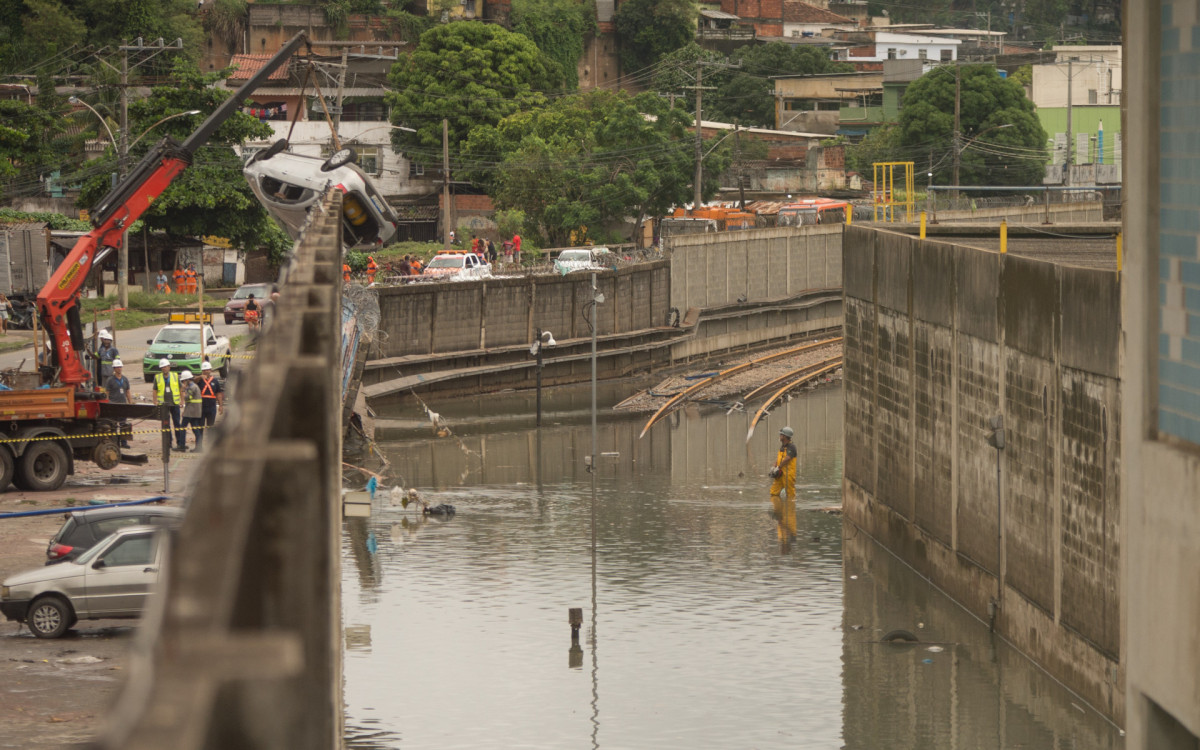 Trilhos amanheceram completamente alagados na altura da estação Acari/Fazenda Botafogo neste domingo. Carro que invadiu local precisou ser retirado