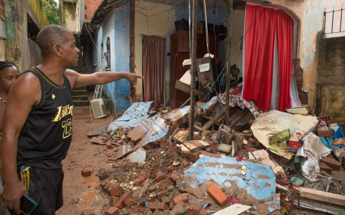 Na foto, moradores da Pavuna mostram os estragos feitos pela chuva em suas casas - Armando Paiva