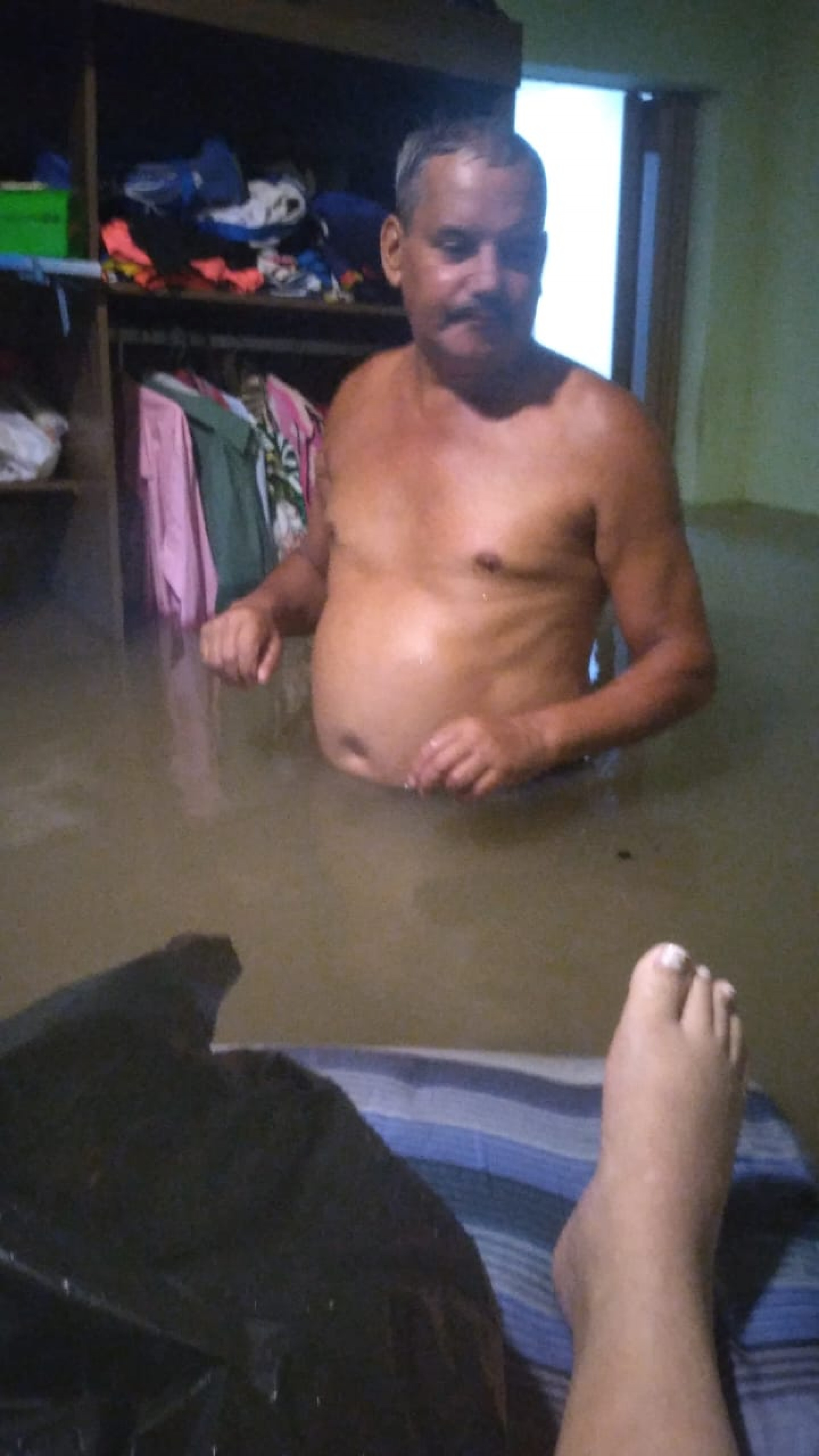 Na foto, tia de Danilo Pinna, no momento em que sua casa foi invadida pelas águas da chuva - Divulgação