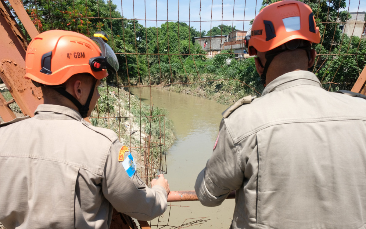 Bombeiros fazem busca por mulher desaparecida no Rio Botas, em Belford Roxo, nesta segunda-feira (15), ap&oacute;s enchentes no fim de semana