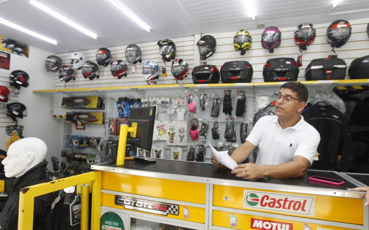 Osvaldo explicando sistema manual usado nas vendas durante a falta de energia - Reginaldo Pimenta/Agência O DIA