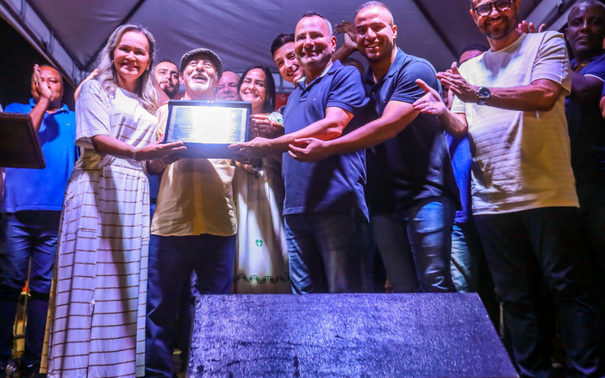 Deputada Daniela do Waguinho e prefeito Waguinho entregam uma placa ao filho de Maria da Conceição Carneiro