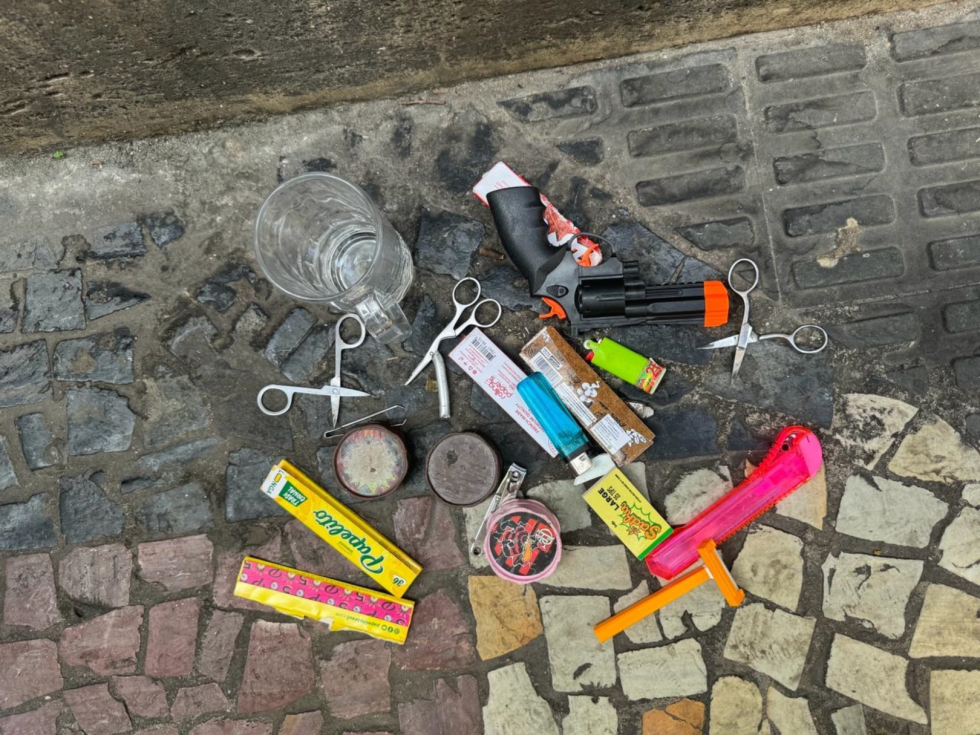 Um revólver de brinquedo e objetos para uso de drogas foram apreendidos - Divulgação / @pmerj