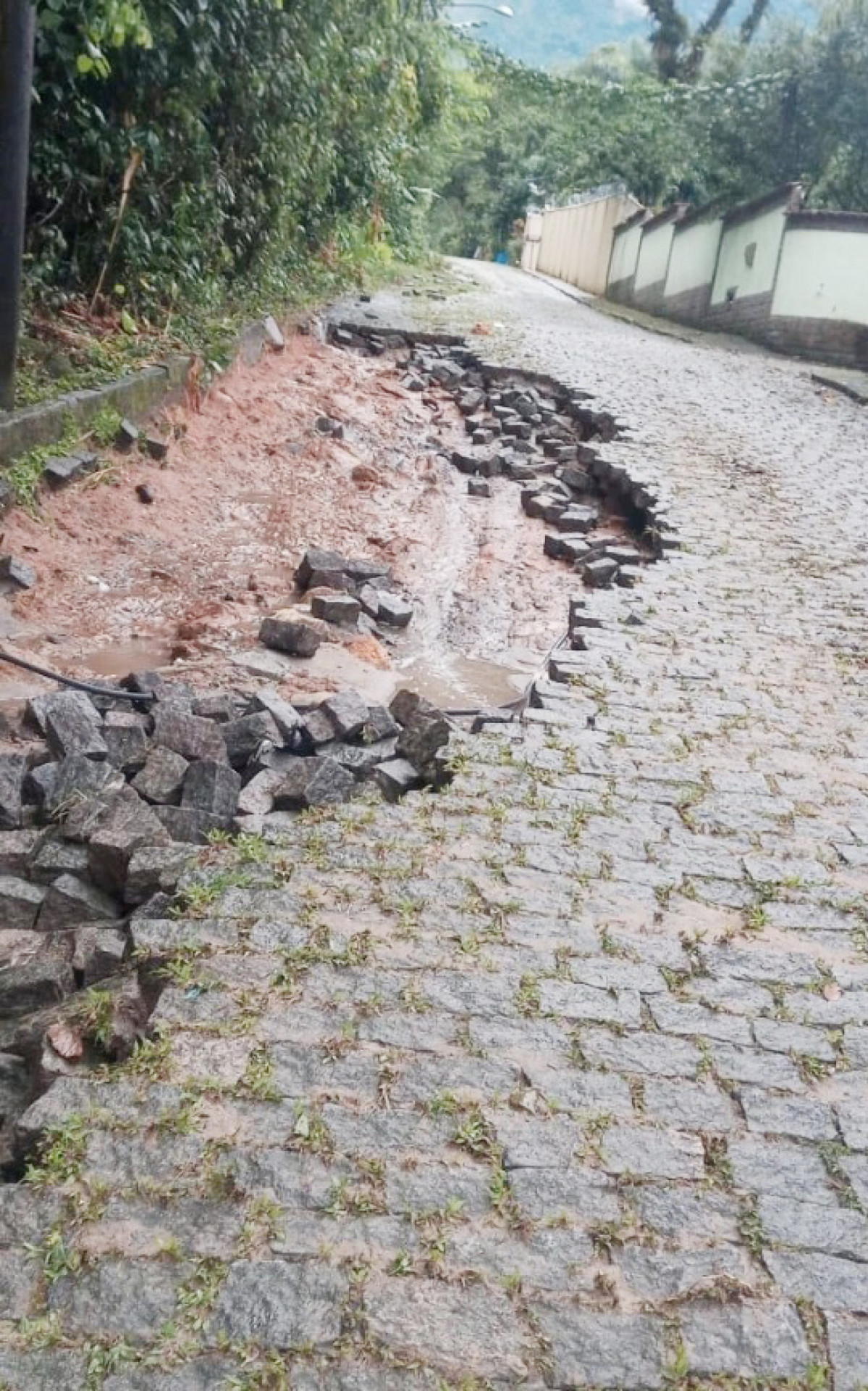 A força da água foi tão grande que arrancou os paralelepípedos na Estrada da Barreira, em Guapimirim - Foto: Redes Sociais - Divulgação