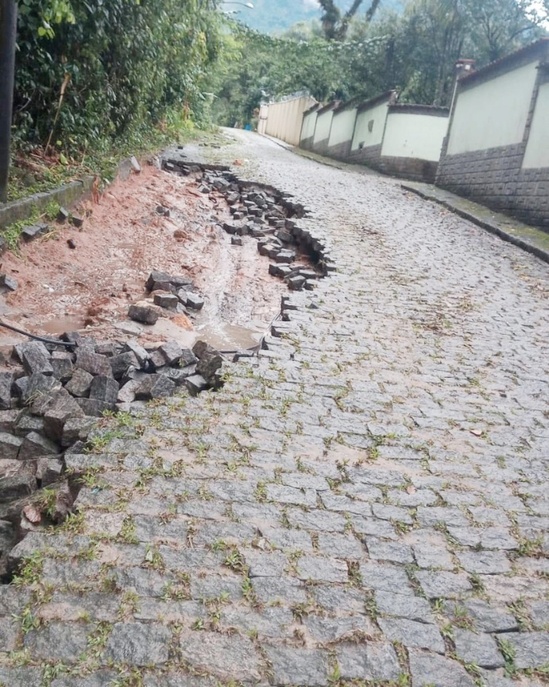 A força da água foi tão grande que arrancou os paralelepípedos na Estrada da Barreira, em Guapimirim