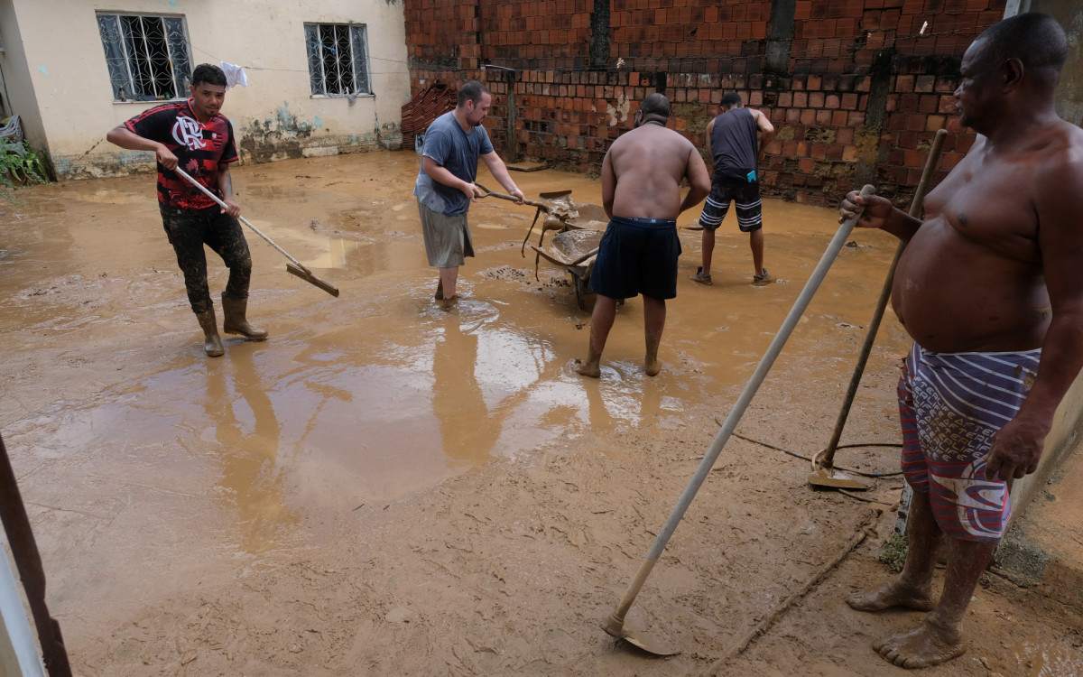 Enchente causa estragos nas ruas de Nova Iguaçu: em meio à lama, moradores salvam o que podem e tentam limpar as casas