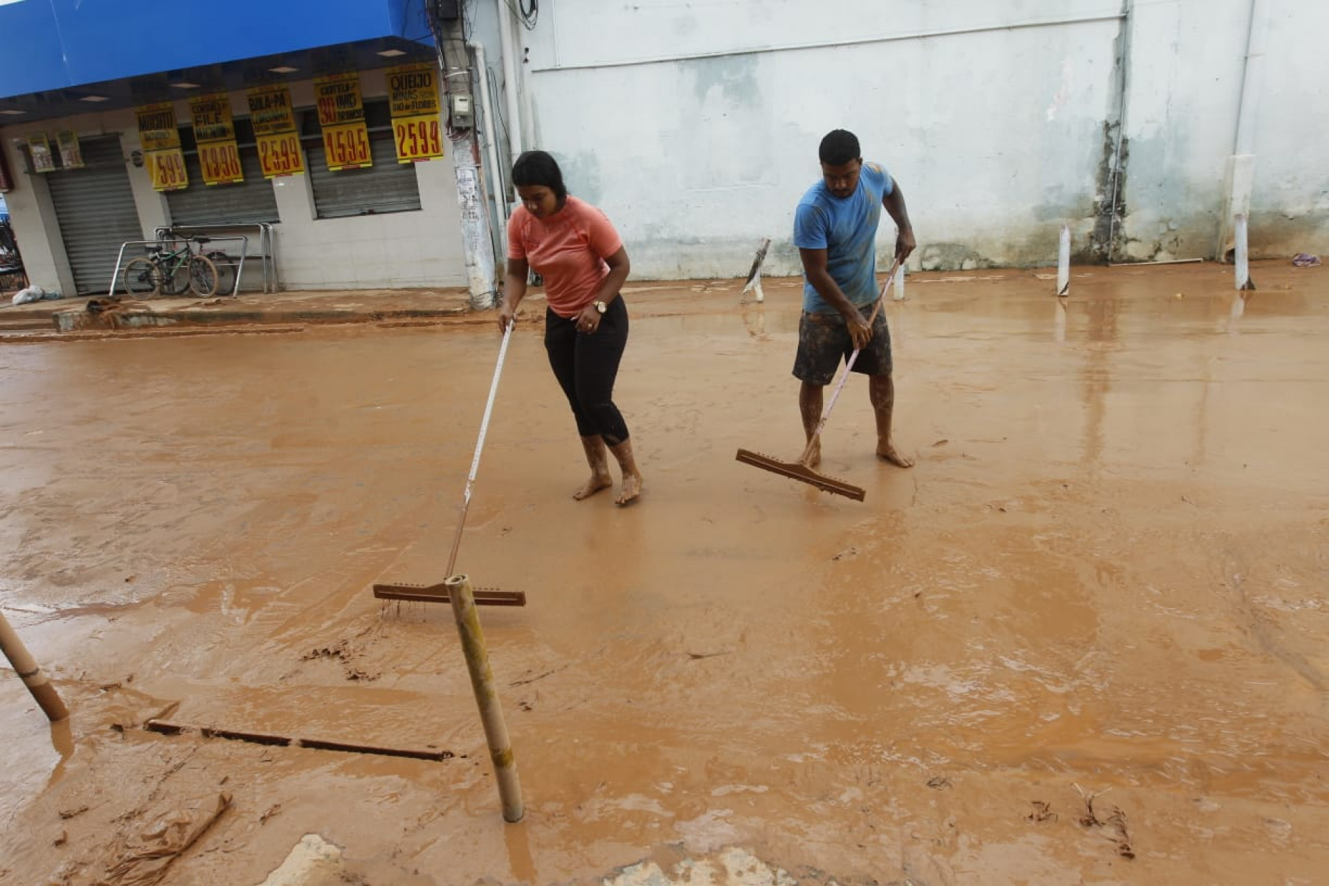 Rua Presidente Vargas com lama após forte chuva em Nova Iguaçu, na Baixada Fluminense. Na foto, Evelyn Araújo e o marido Alisson Araújo - Reginaldo Pimenta/Agência O Dia