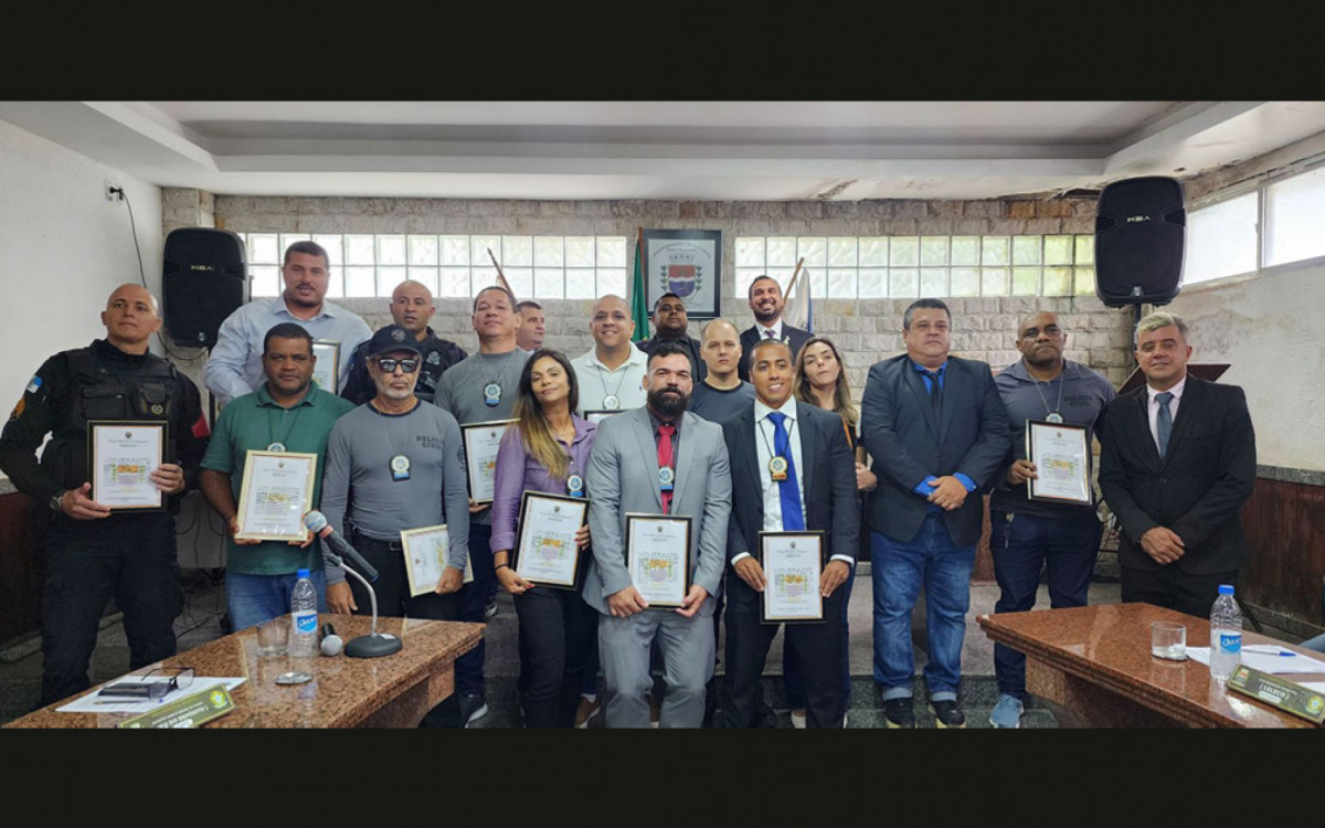 Os nove policiais civis homenageados seguram suas moções de aplausos na Câmara Municipal de Guapimirim