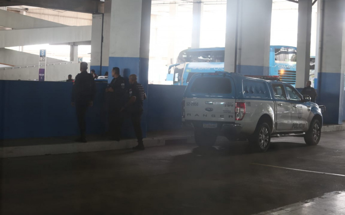 Policiais militares na pista em que ônibus circulam na Rodoviária do Rio, próximos ao veículo que foi sequestrado 