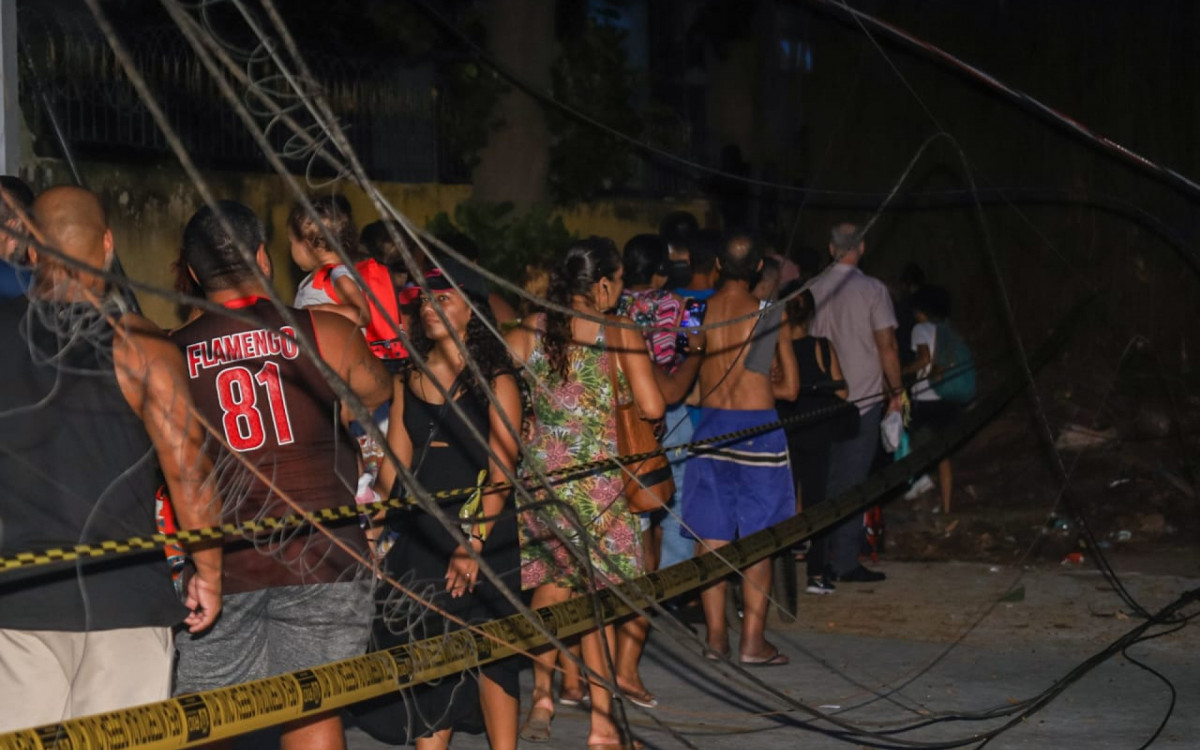 Pessoas fazem fila para passar por trás de árvore caída - Renan Areias/Agência O Dia