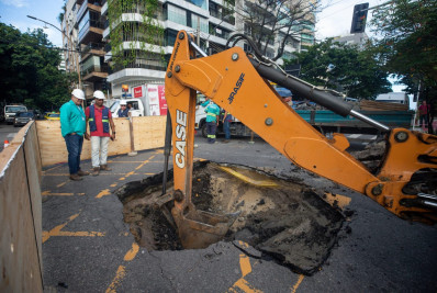 Motociclista cai dentro de cratera aberta em rua na Zona Sul