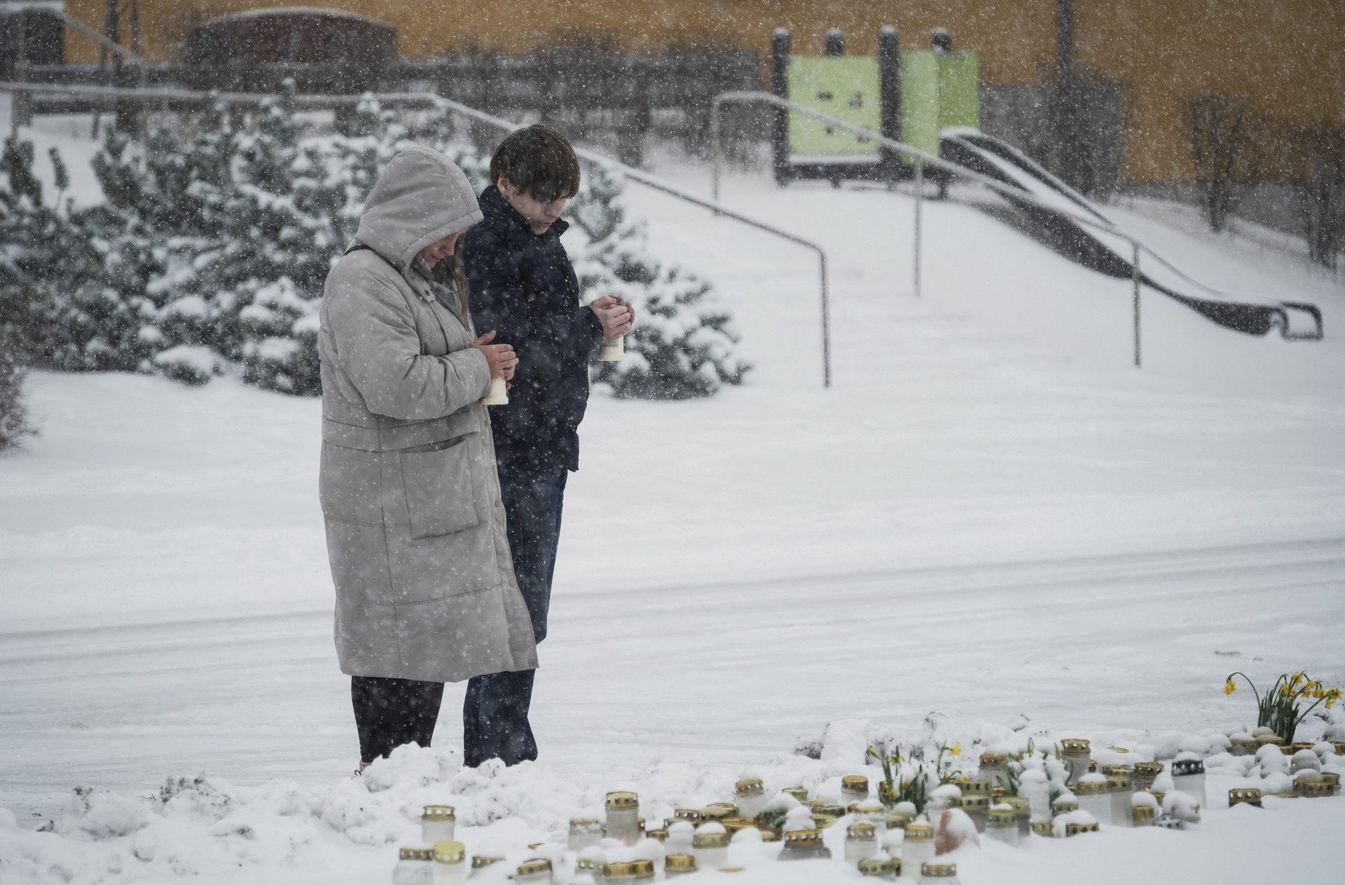 Pessoas depositam flores e velas para homenagear as v&iacute;timas do tiroteio em escola na Finl&acirc;ndia - Alessandro Rampazzo / AFP