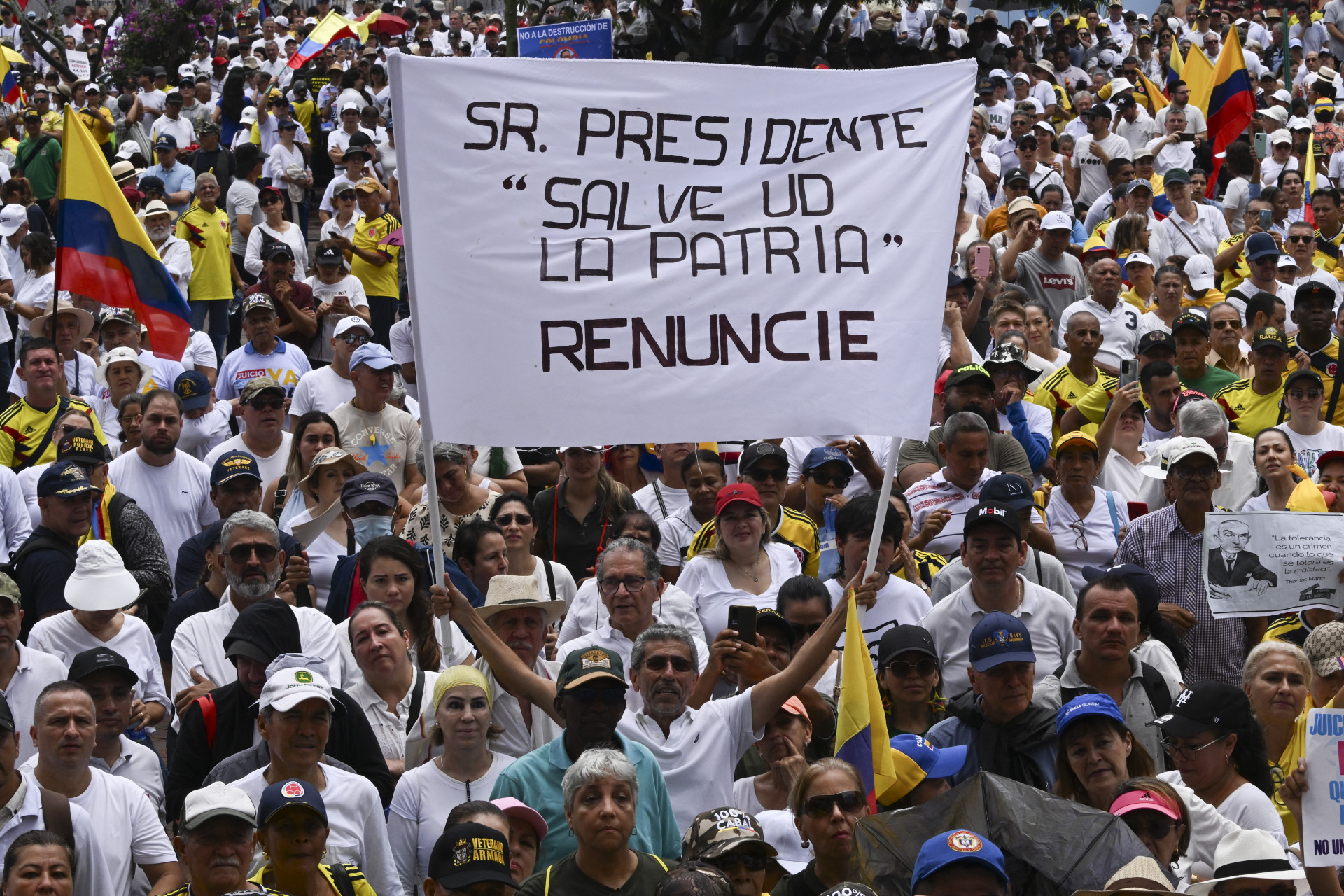 Um manifestante segura uma placa que diz 'Sr. Presidente, salve a pátria. Renuncie' - AFP