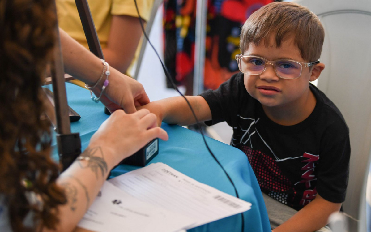 Menino faz biometria para emissão de documento