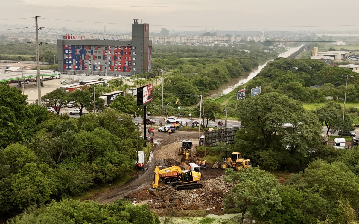 Trabalhadores reforçando um dique às margens do rio Guaíba, Porto Alegre, RS - AFP
