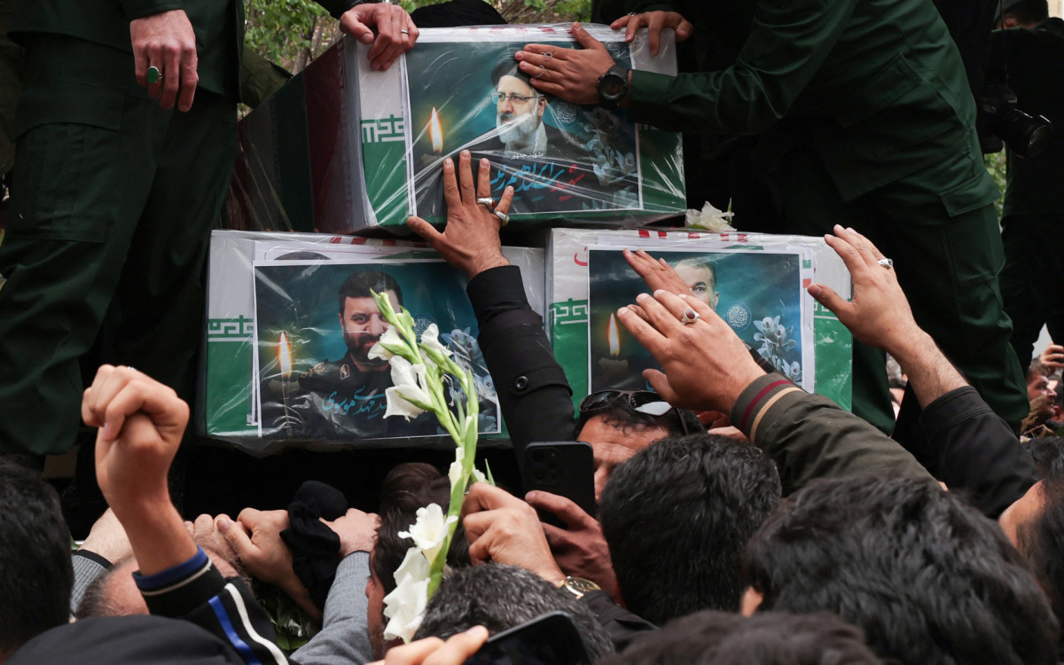Multidão em luto reunida em torno do caixão durante o cortejo fúnebre - AFP