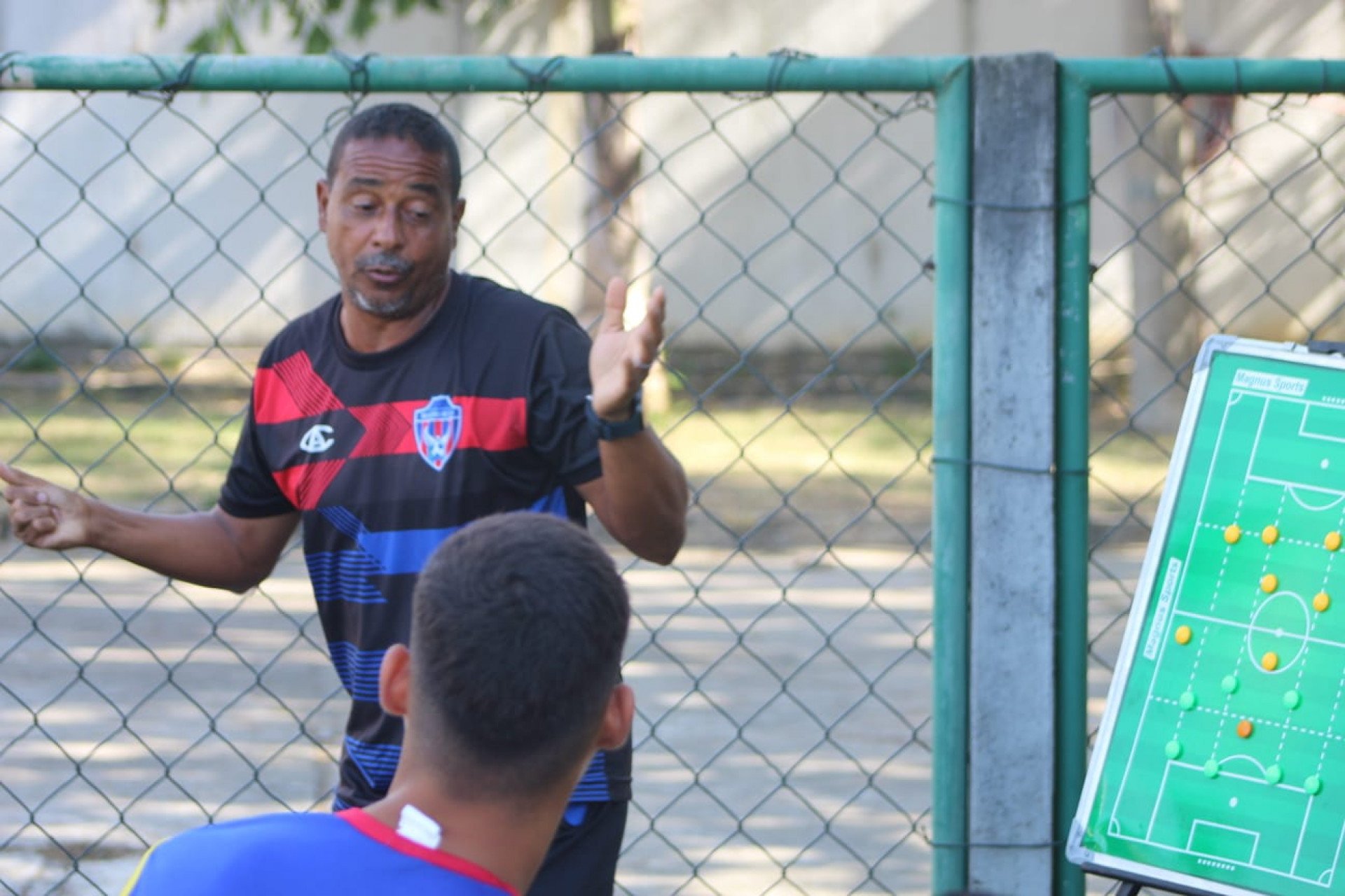  O coordenador Custódio Junior mostrando o esquema de jogo para os jovens atletas - Isaac Timóteo / SEBR