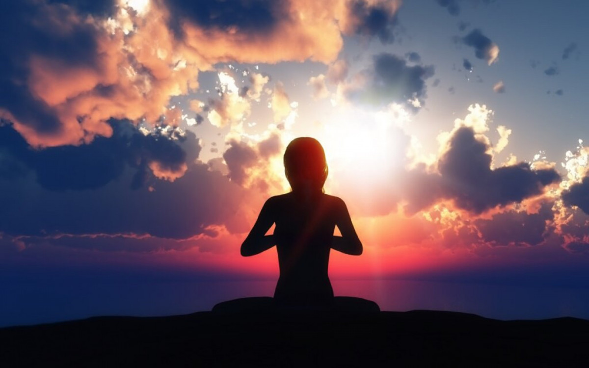 3D render of a female in a yoga pose against a sunset sky