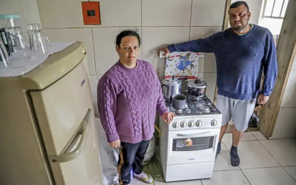 Lisiane Correia e o marido Fábio Junior Quintera mostram fogão e geladeira que compraram com o auxílio do governo