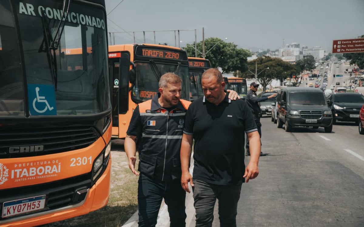 Marcelo Delaroli ao lado do irmão Guilherme Delaroli e dos ônibus gratuitos de Itaboraí - Foto: Divulgação
