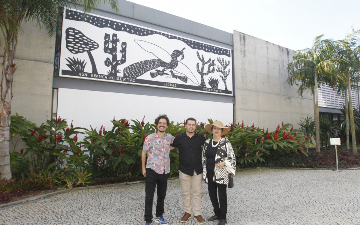 Homenagem ao artista nordestino J. Borges, ícone da xilogravura brasileira, durante a festa Junina do Museu do Pontal, na Barra. O local é conhecido por promover e valorizar a cultura popular e o folclore. Na foto,  Pablo Borges, ao centro e os diretores do Museu do Pontal, Lucas Van de Beuque e Angela Mascelani. - Reginaldo Pimenta/Agência O Dia