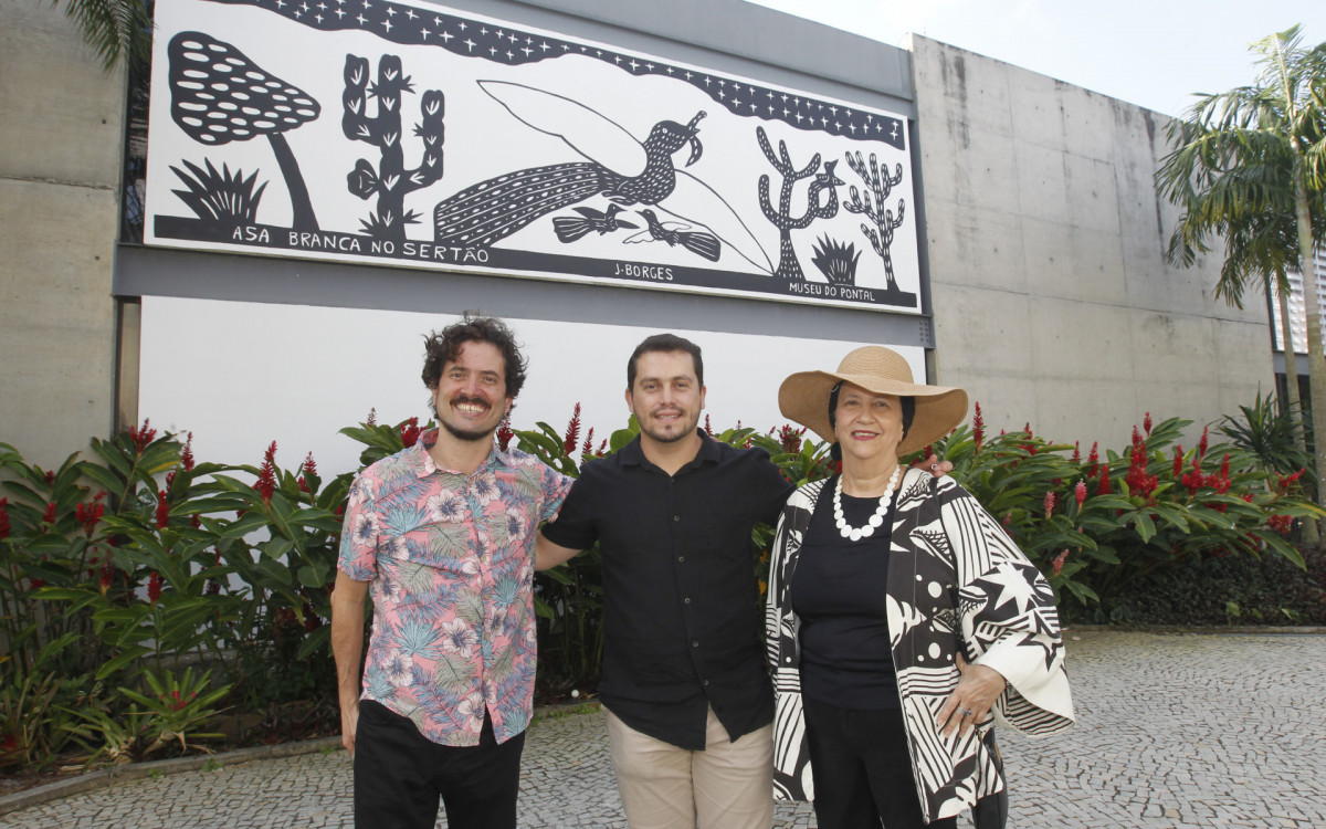 Homenagem ao artista nordestino J. Borges, ícone da xilogravura brasileira, durante a festa Junina do Museu do Pontal, na Barra. O local é conhecido por promover e valorizar a cultura popular e o folclore. Na foto,  Pablo Borges, ao centro e os diretores do Museu do Pontal, Lucas Van de Beuque e Angela Mascelani. - Reginaldo Pimenta/Agência O Dia