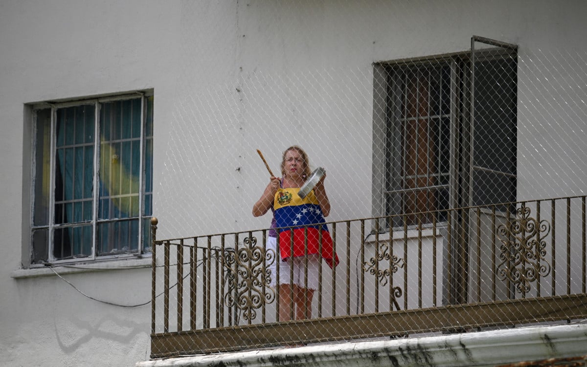 Mulher protesta em varanda após resultado das eleições - AFP