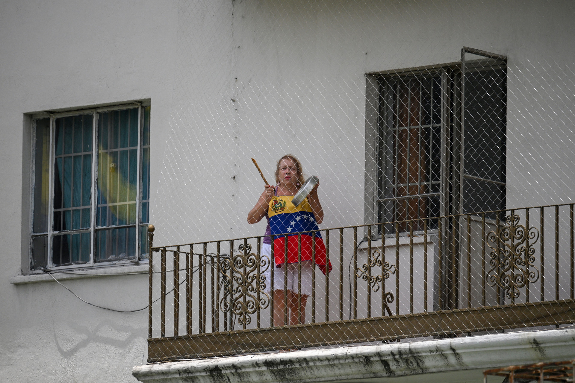 Mulher protesta em sua varanda - Frederico Parra/AFP