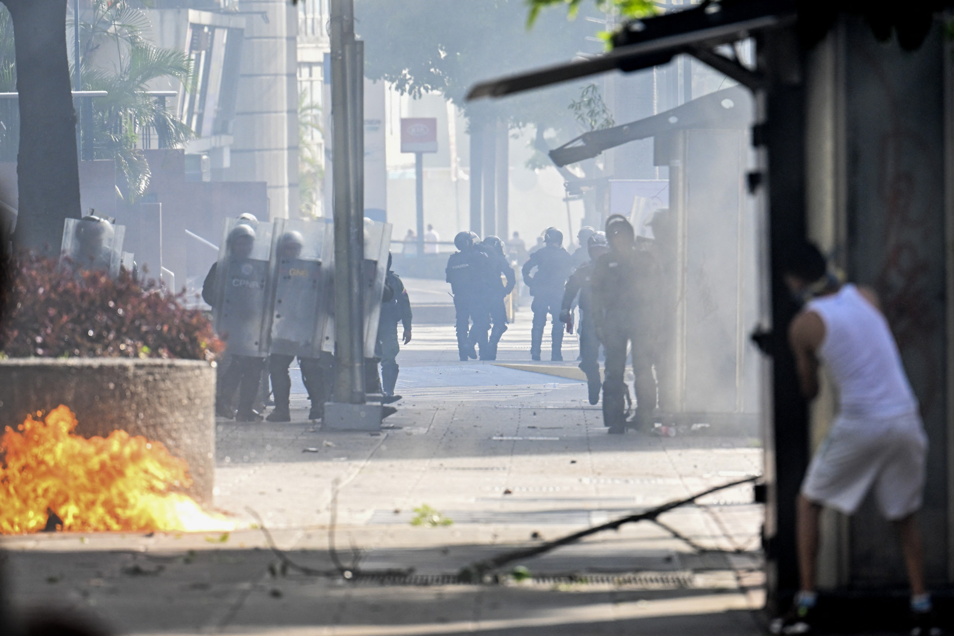 Homem se esconde enquanto polícia se aproxima - Juan Barreto/AFP