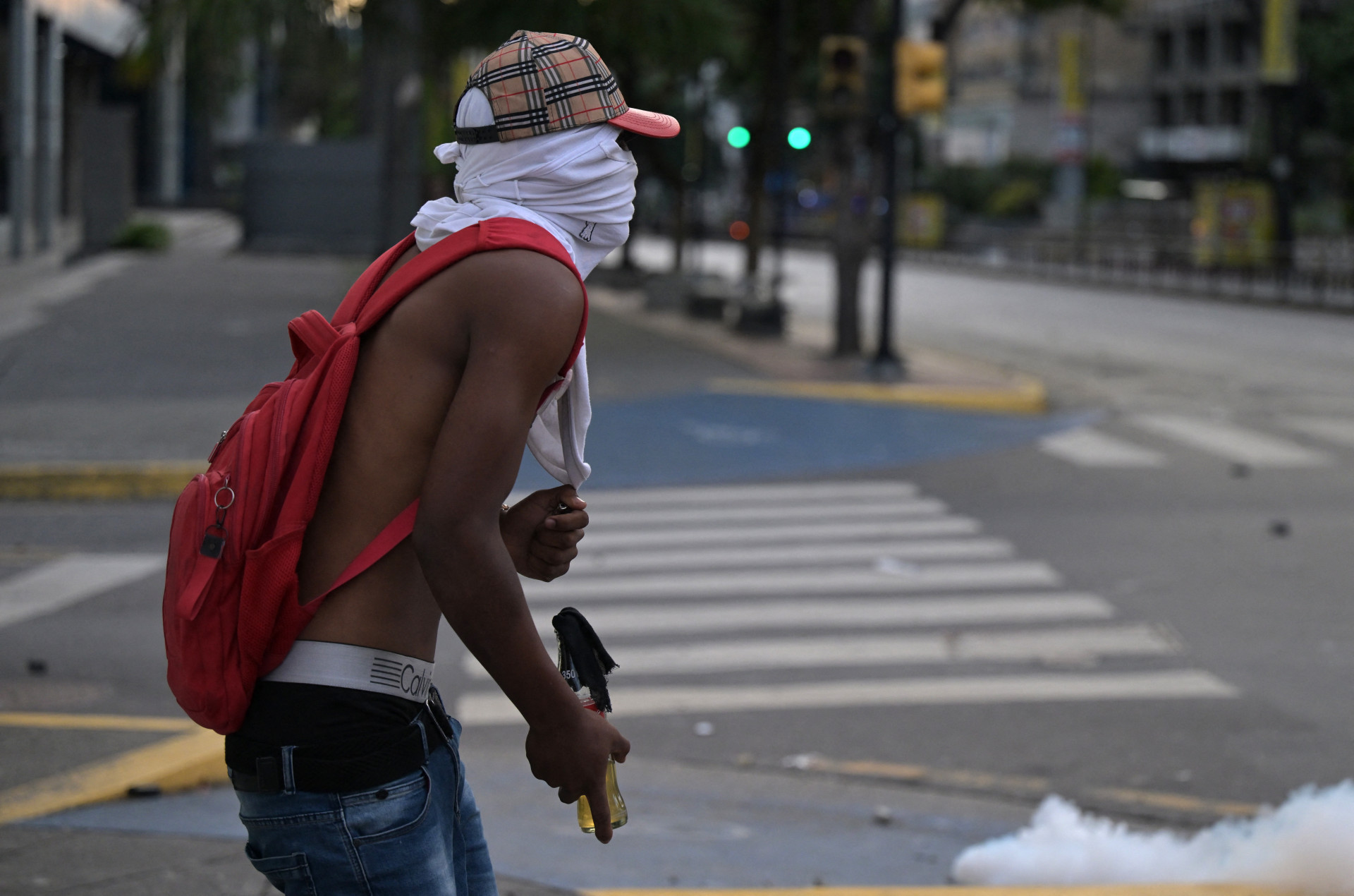 Homem armado com coquetel molotov circula pelas ruas de Caracas - Yuri Cortez/AFP