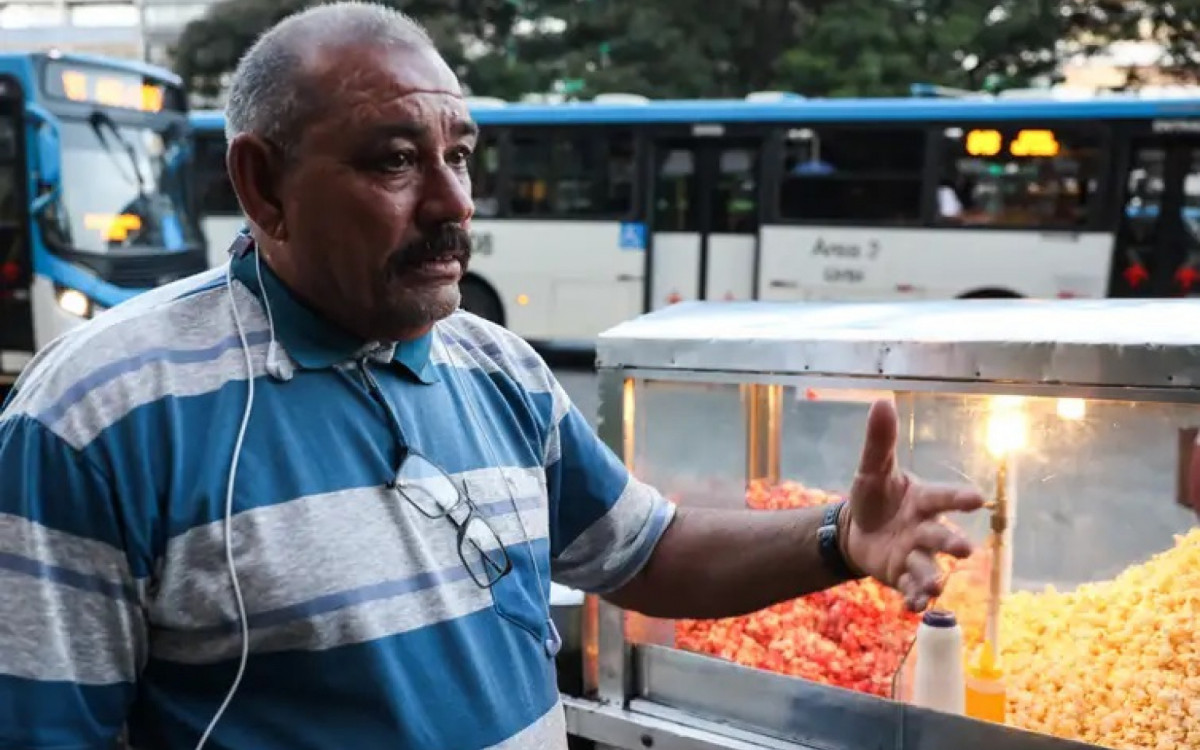 Enquanto vende pipoca, Gil Lopes usa os fones para ouvir mensagens dos filhos
