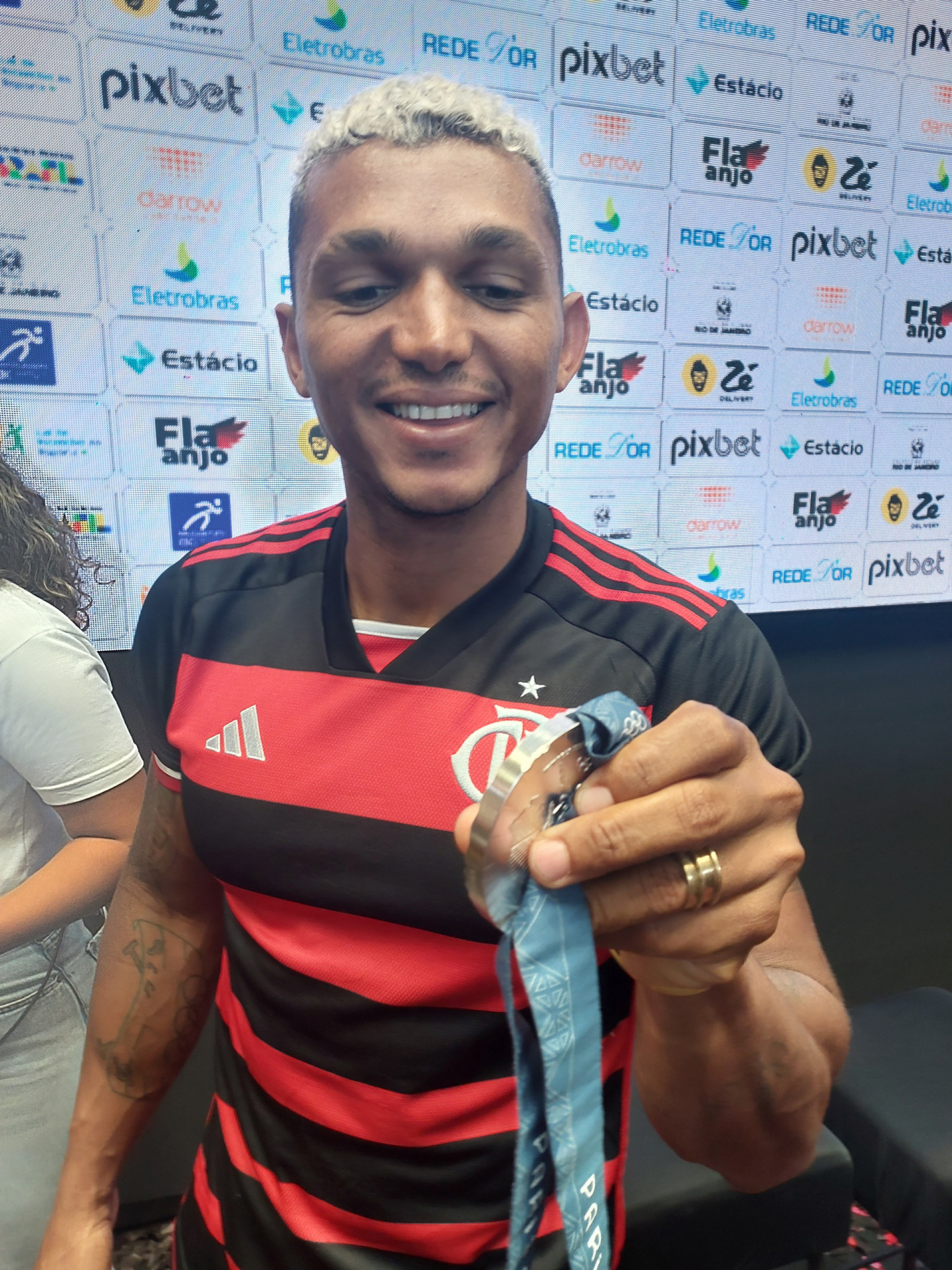 Isaquias Queiroz mostra medalha de prata lascada após queda em comemoração com o filho