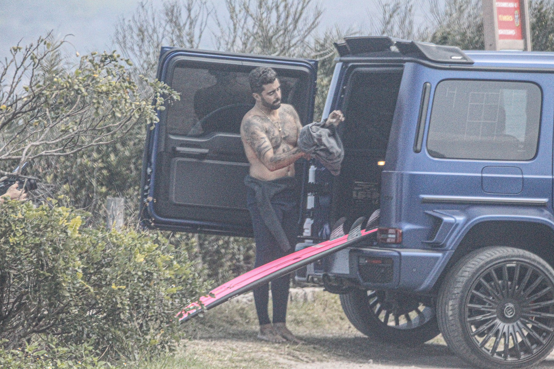 Pedro Scooby troca de roupa na praia de Grumari em dia de gravação
 - Delson Silva / AgNews