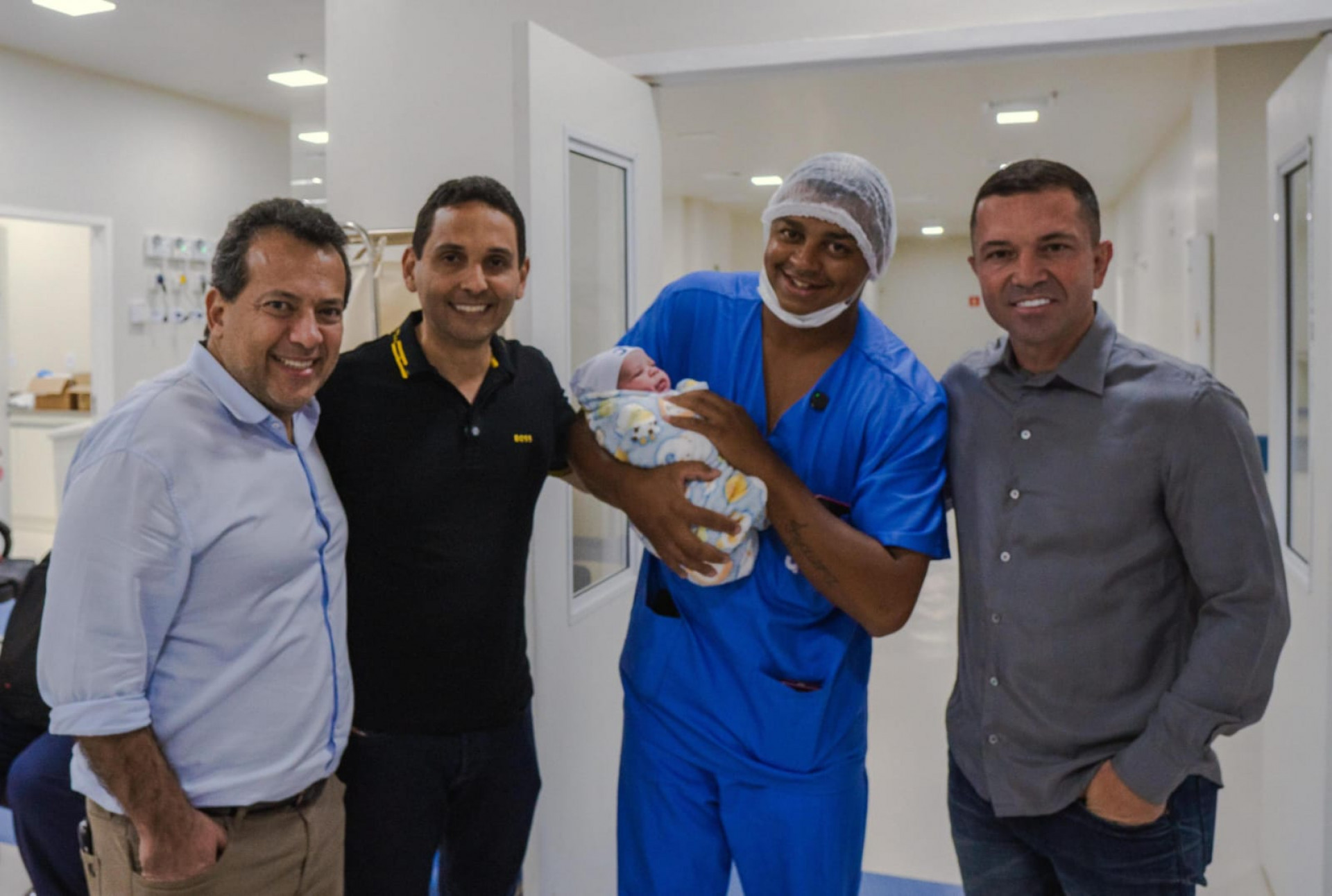 Leandro Souza Medeiros com o filho Kalleb no colo, ao lado do prefeito Abraãozinho (camisa preta) e dos deputados Ricardo Abraão e Rafael Nobre, que foram felicitar os pais - Giulia Nascimento / PMN