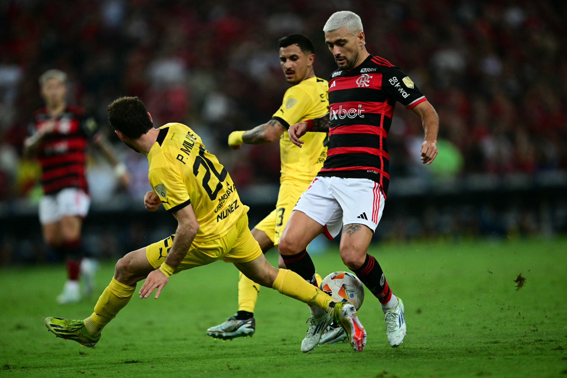 Arrascaeta, do Flamengo, em dividida no jogo contra o PeÃ±arol pela Libertadores - Mauro Pimentel/AFP