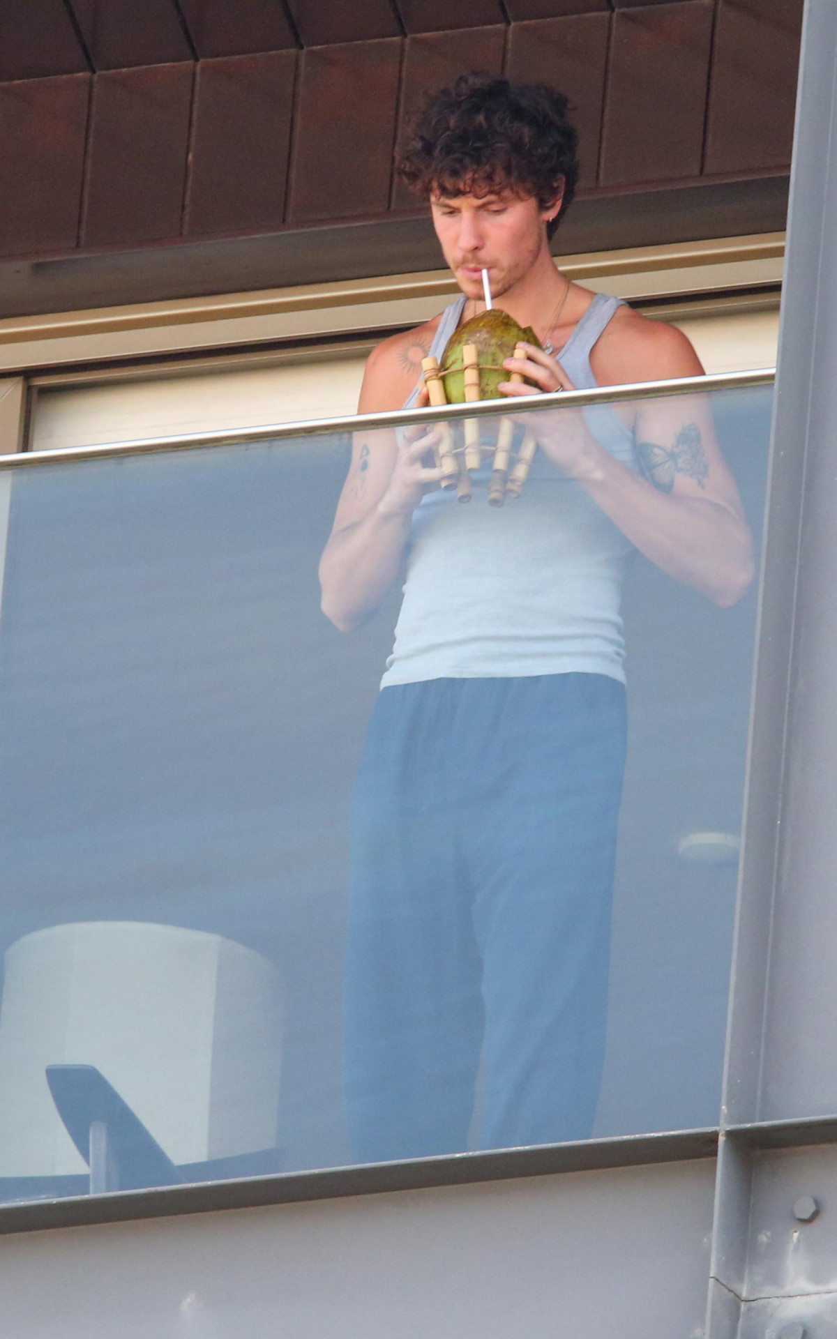 Shawn Mendes se refrescando com uma água de coco, após chegar no Rio