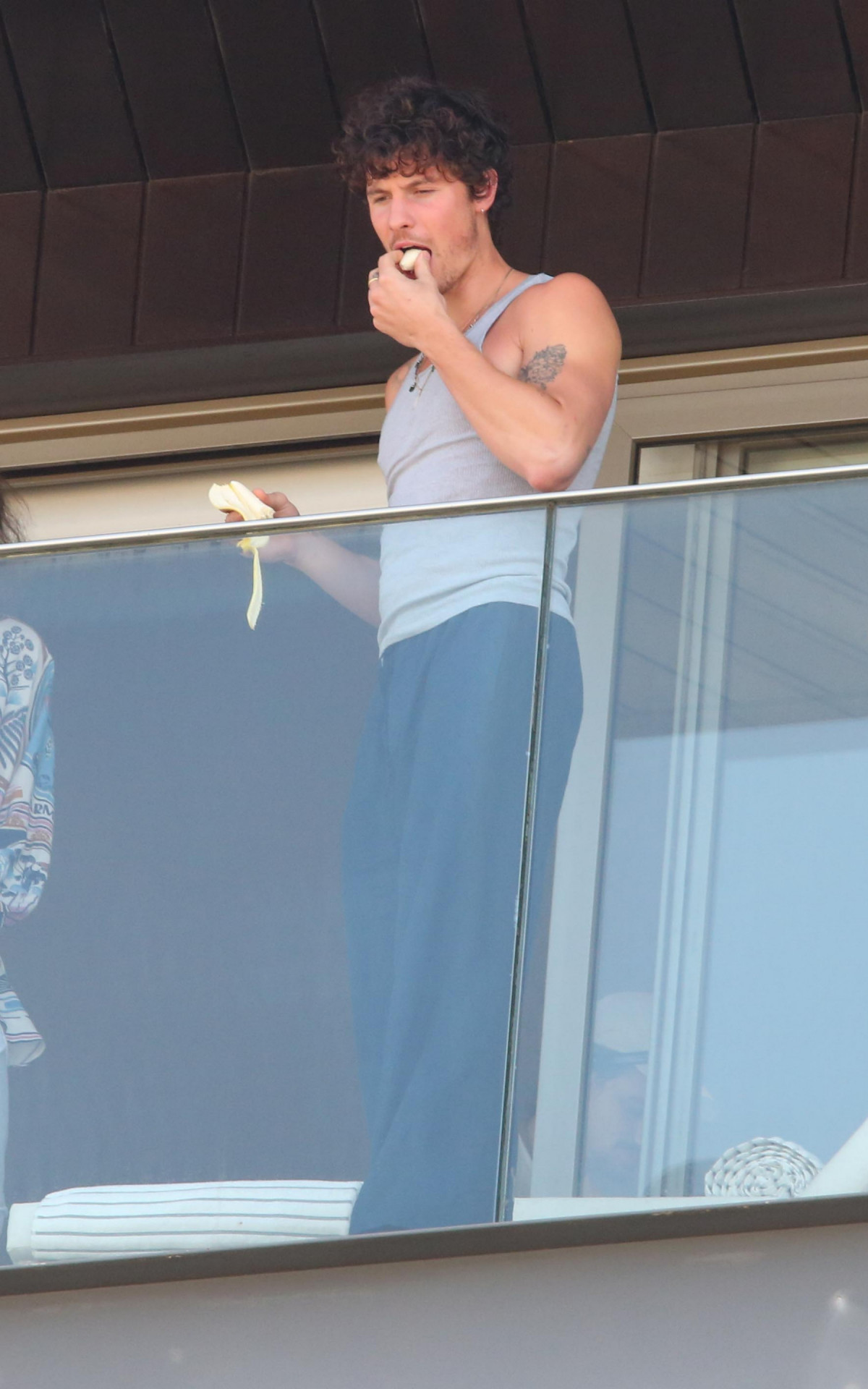Shawn Mendes comendo banana em varanda de hotel com vista para a Praia de Ipanema, Zona Sul do Rio