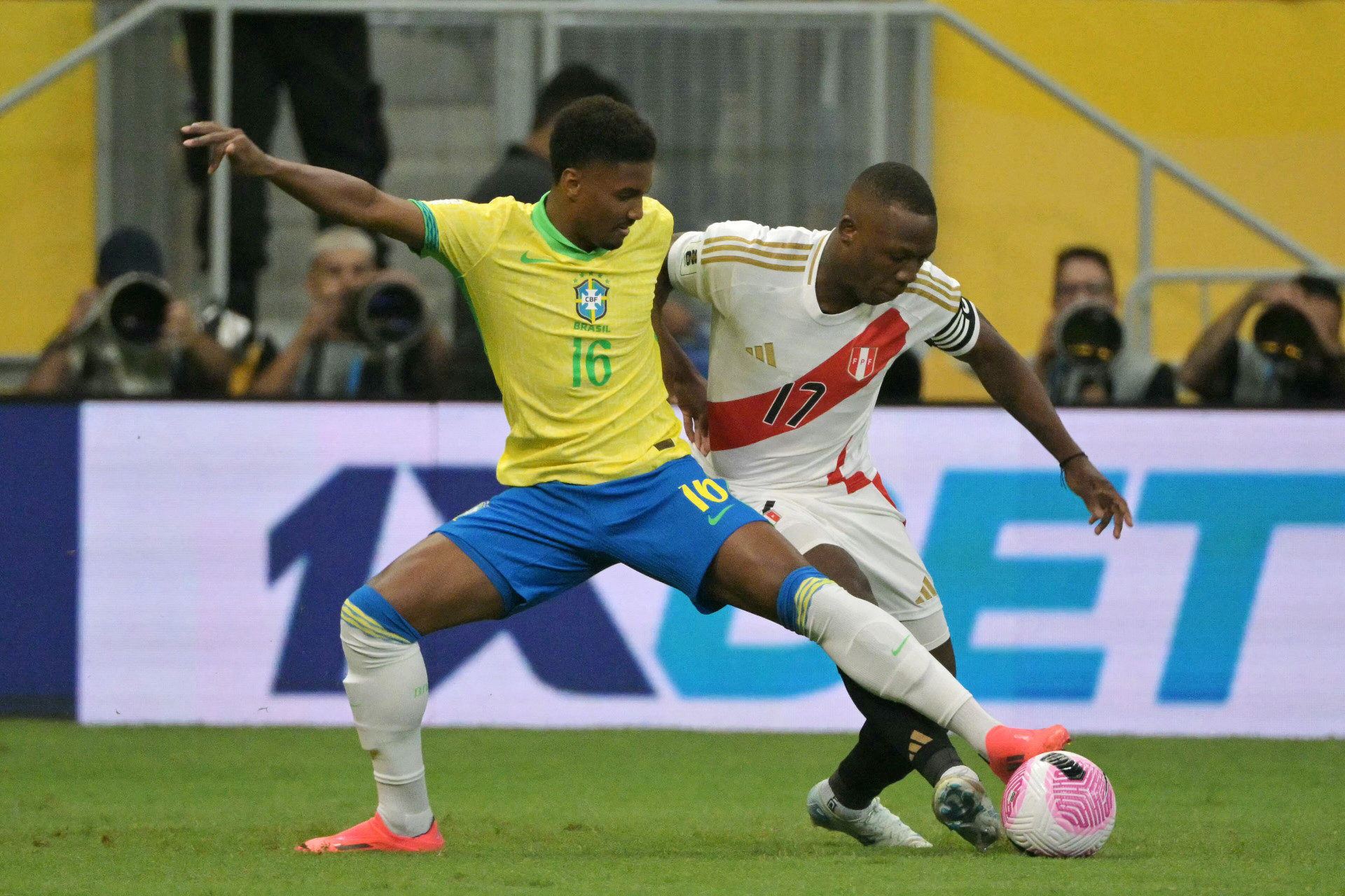 Brazil's defender #16 Abner and Peru's defender #17 Luis Advincula fight for the ball during the 2026 FIFA World Cup South American qualifiers football match between Brazil and Peru at the Mane Garrincha stadium in Brasilia on October 15, 2024. - NELSON ALMEIDA/AFP