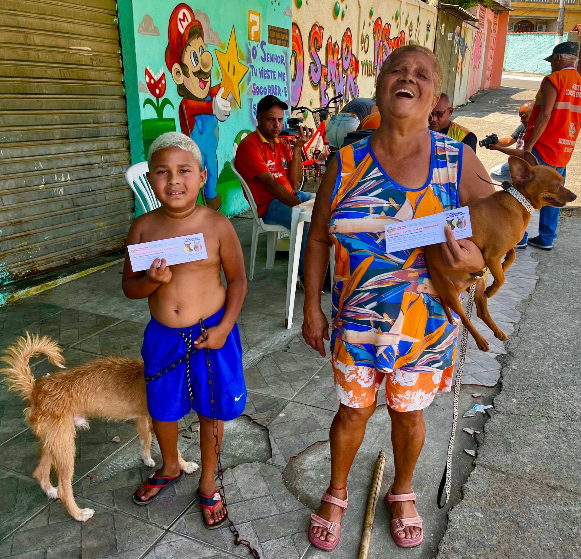 Dona Vitória, acompanhada do neto Paulo, levou o cachorro Caramelo para ser vacinado - Gilberto Rocha /PMBR