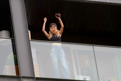 Rosé, integrante do Blackpink, acena para fãs da varanda de hotel no Rio