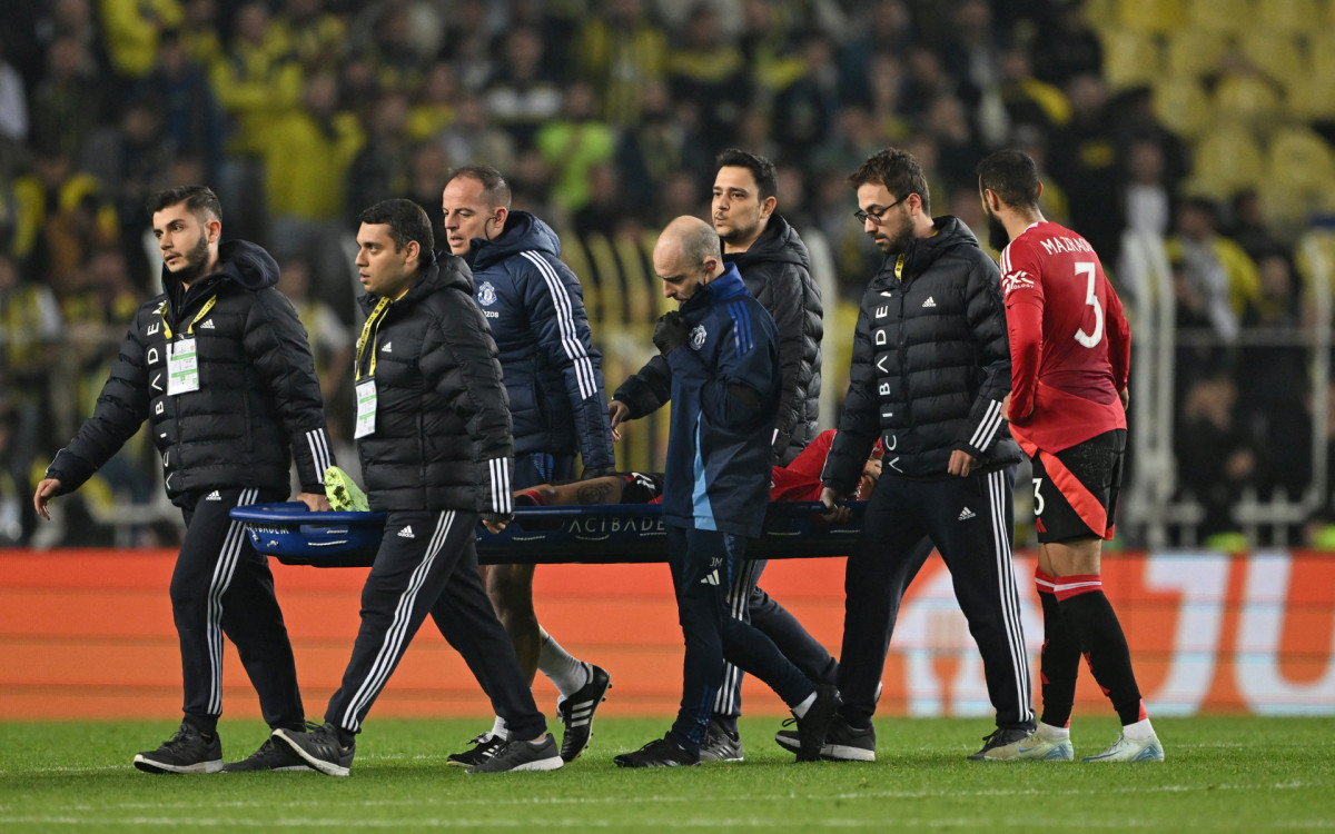 Antony, do Manchester United, deixa o campo de maca