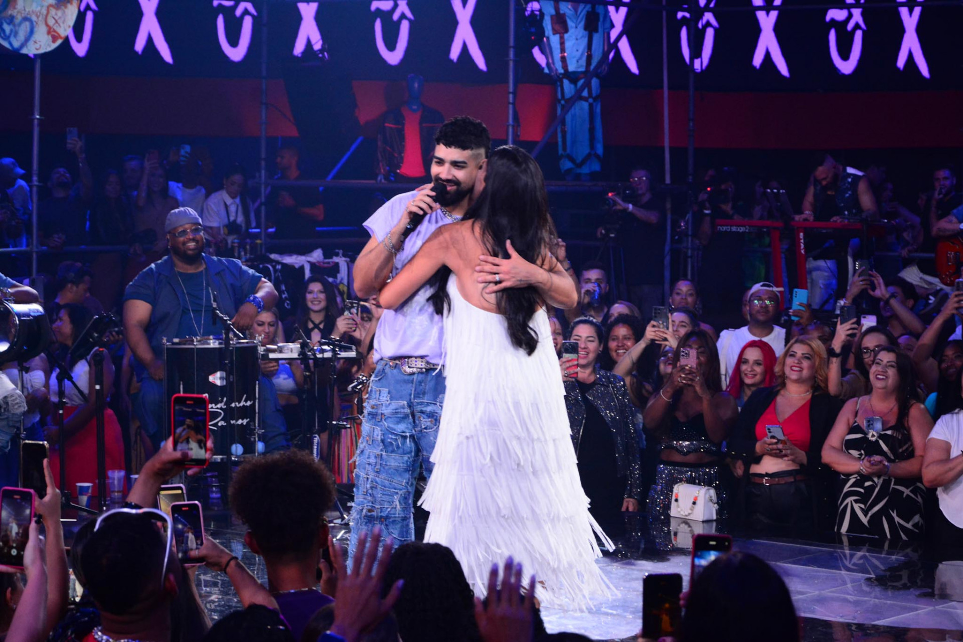 Grávida, Beatriz Ferraz troca carinhos com o marido, Dilsinho, no palco - Belicio / Agnews