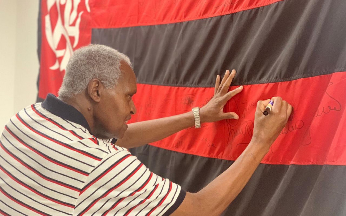 Fio Maravilha autografando uma bandeira fo Flamengo