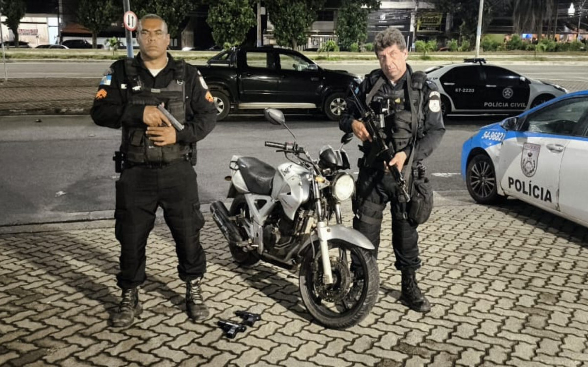 Policiais exibem moto recuperada e réplicas de pistolas apreendidas durante a ação