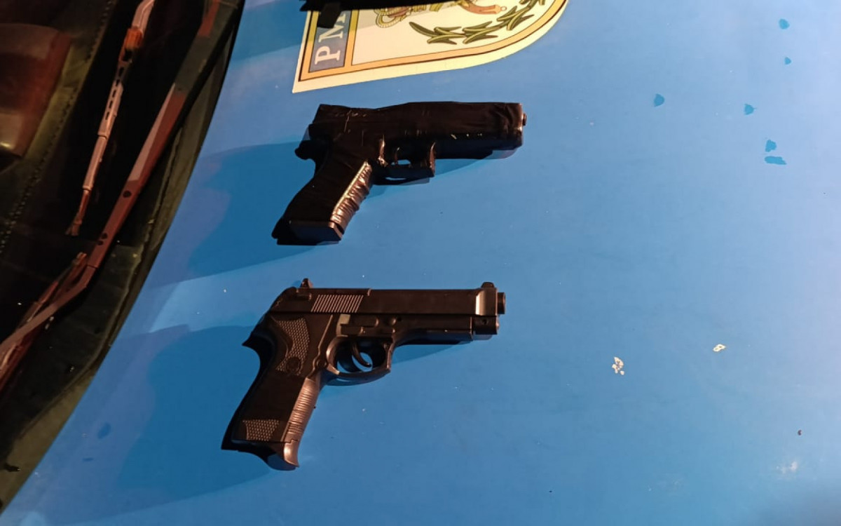 Policiais exibem moto recuperada e réplicas de pistolas apreendidas durante a ação