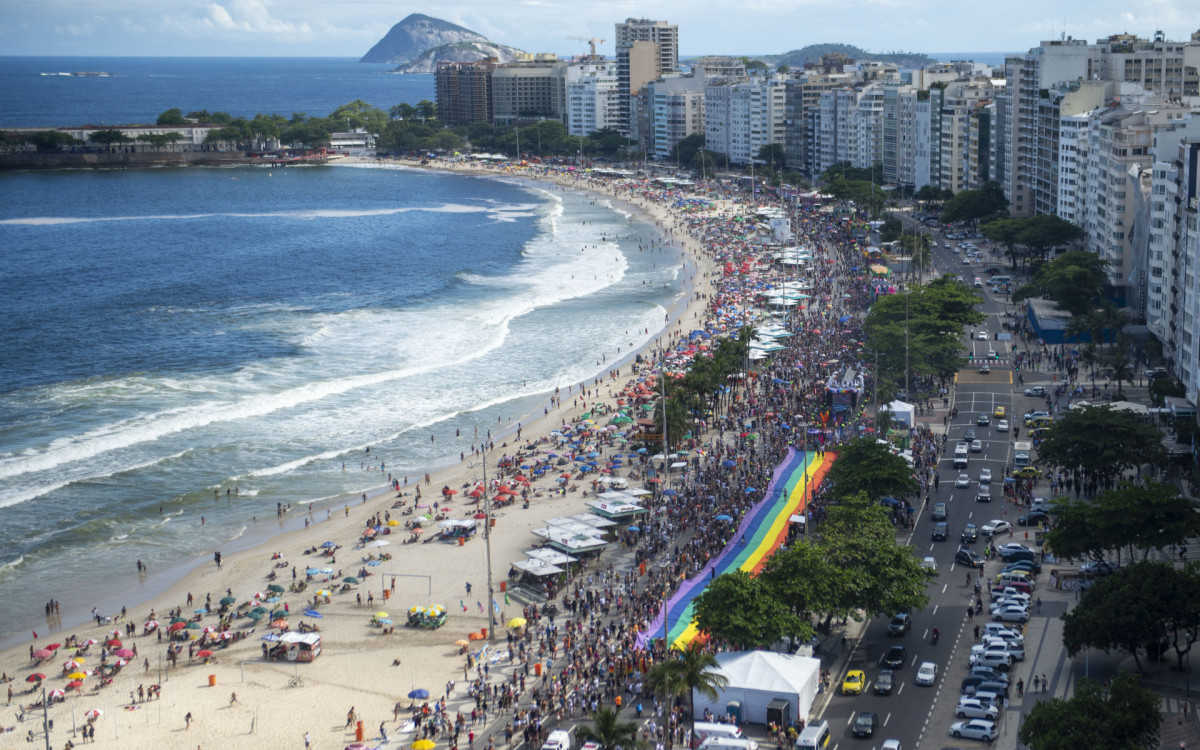 Milhares de pessoas lotaram o calçadão de Copacabana para celebrar a parada LGBTQIA+. Uma enorme bandeira simbolizando o movimento foi estendida na Avenida Atlântica