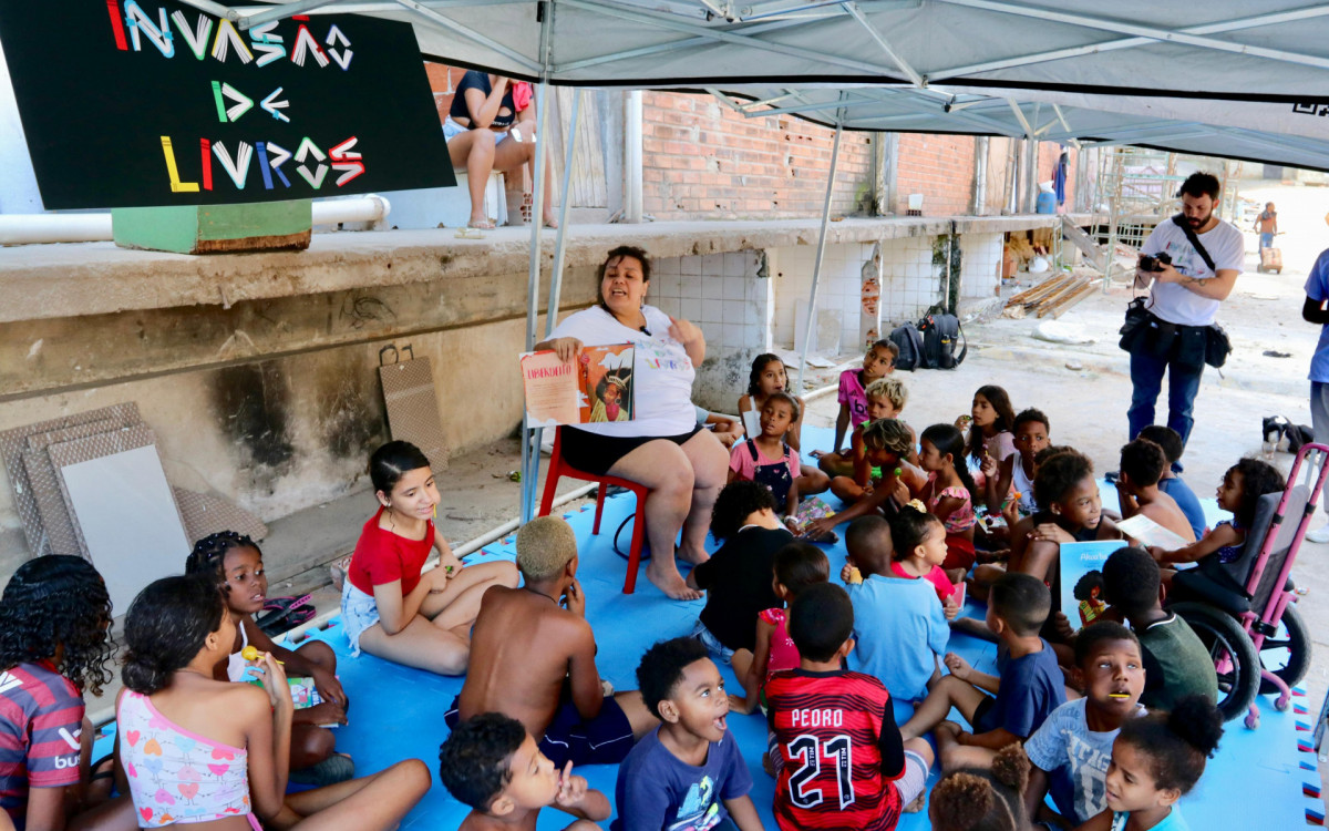 Voluntários entregam livros para crianças durante a ação