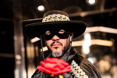 Belo surge mascarado como 'defensor dos corações apaixonados' e namorada reage